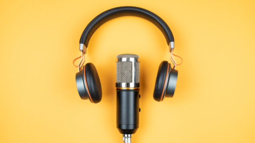 directly above view of headphones and recording microphone on orange background